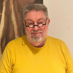 Porträt Andreas Krüger – Mann mit Brille in gelbem Shirt