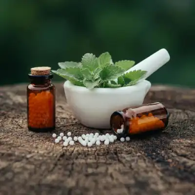 Homöopathische Mittel – Mörser mit Kräutern, Glasflaschen und Globuli