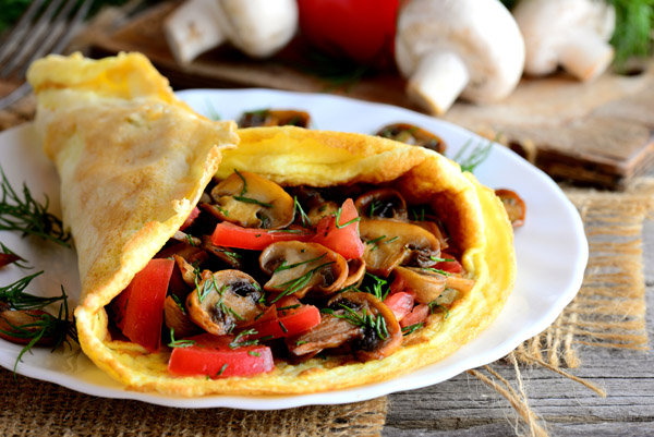 Low Carb – Abnehmkurs mit Ernährungsplan von OnVersum GmbH 5 Low Carb Wrap mit Pilzen, Paprika und Gemüsefüllung auf Holzbrett