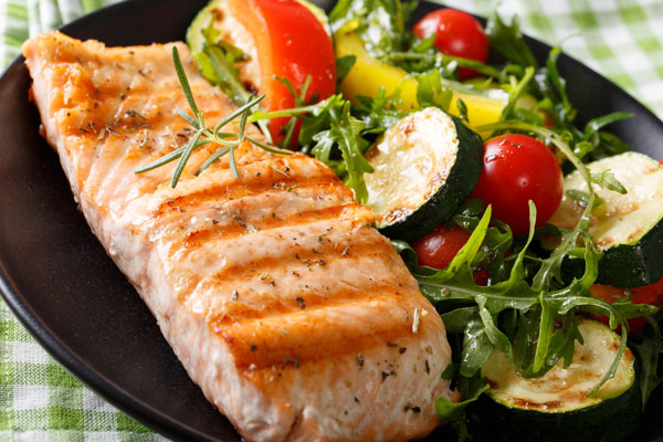 Low Carb – Abnehmkurs mit Ernährungsplan von OnVersum GmbH 11 Gegrillter Lachs mit Gemüse und Rucola auf schwarzem Teller