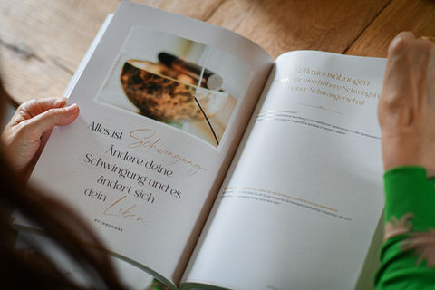 Aufgeschlagenes Maloori Begleitbuch zeigt Text und Aquarell-Illustration