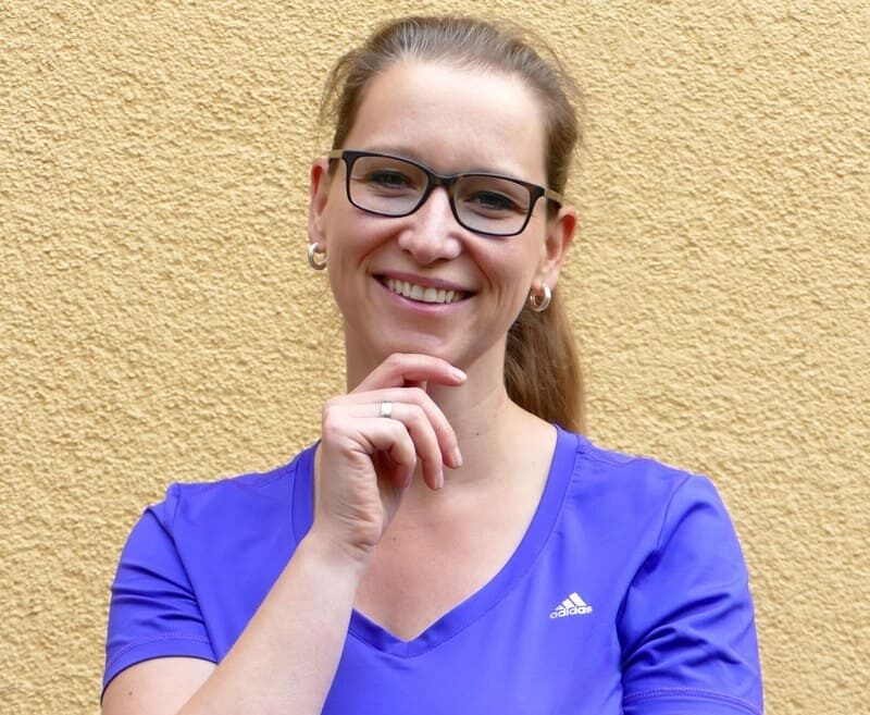 Lächelndes Porträt von Kathleen Piotter vor gelber Wand