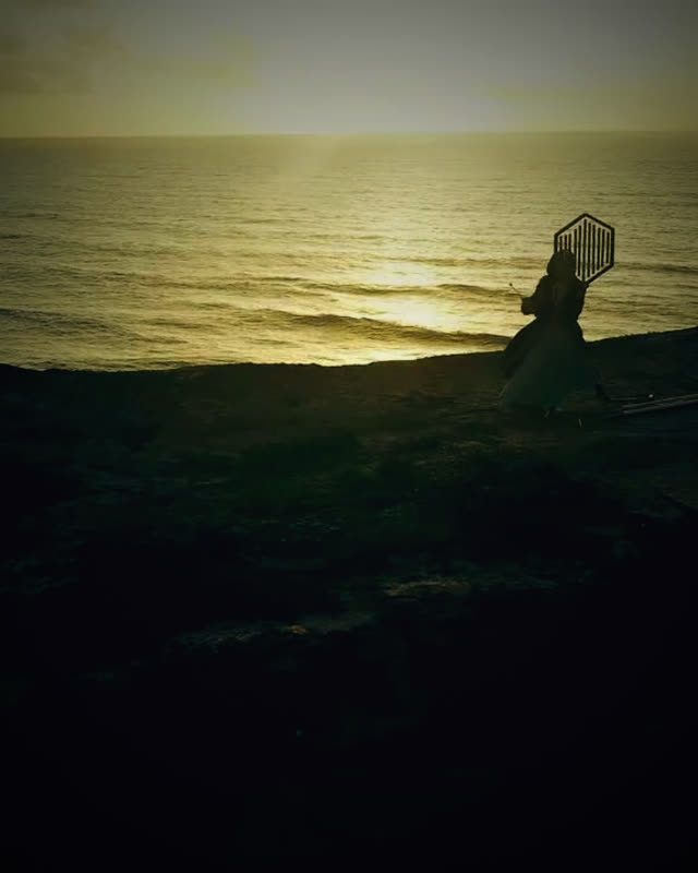 Silhouette einer Person mit geometrischer Form am Strand bei Sonnenuntergang