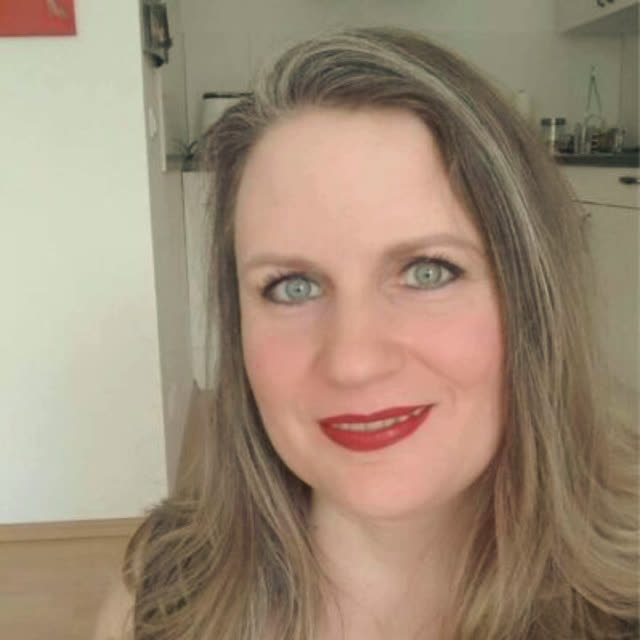 Frau mit grünen Augen und roten Lippen in dunklem Hintergrund