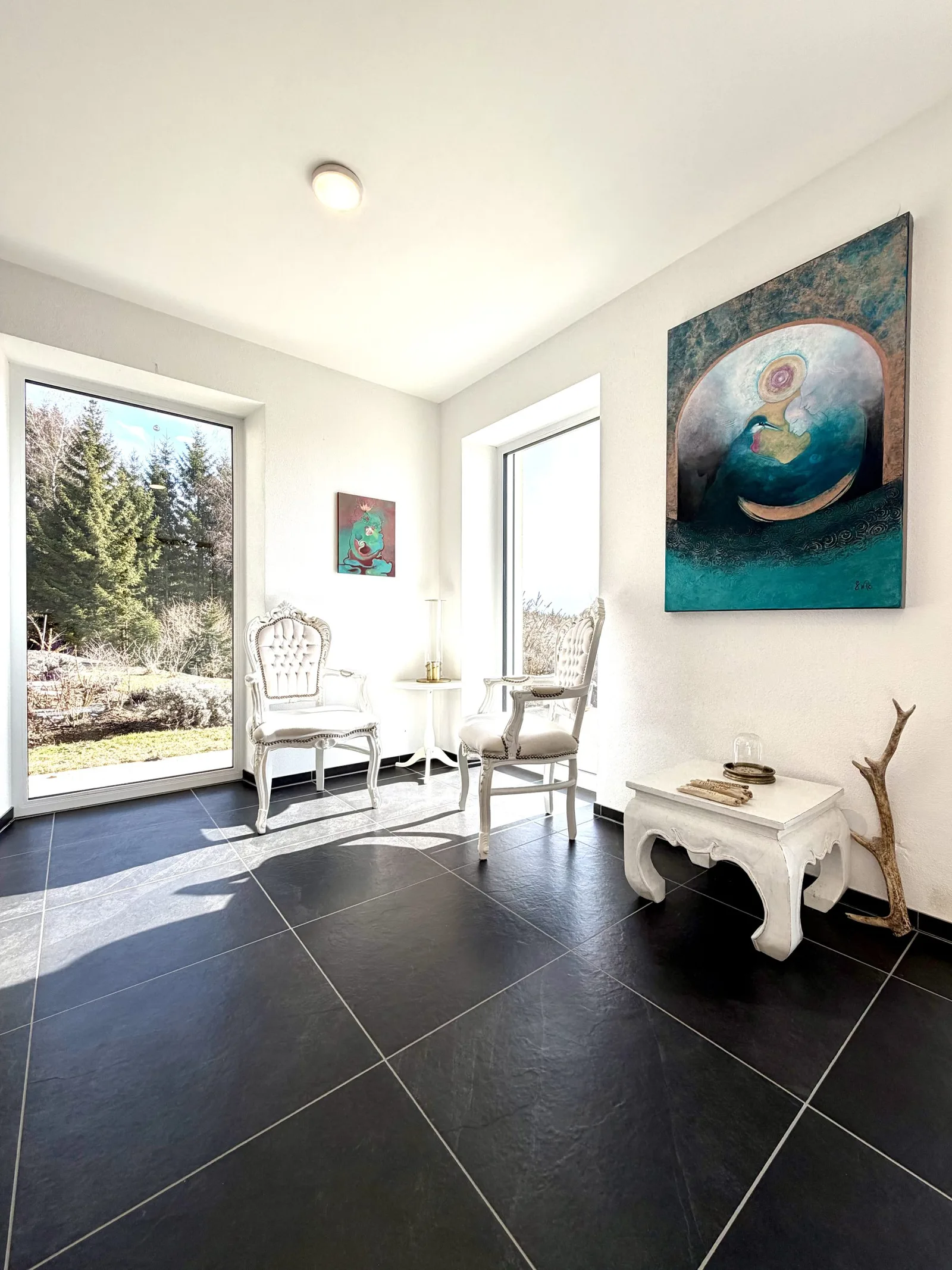 Helles Coaching-Studio mit Türen, Stühlen, Gemälden und Blick auf Natur
