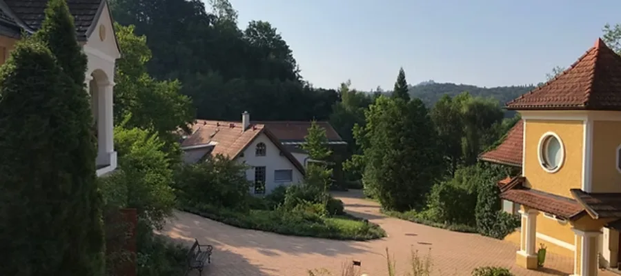 Luftaufnahme eines Seminarorts mit Haupthaus und Nebengebäuden, umgeben von Wald
