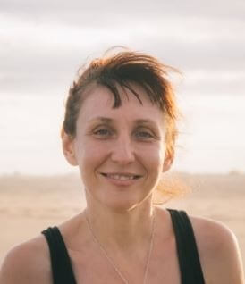 Kundenstimme von Kathrin B., Frau mit rötlichem Haar am Strand