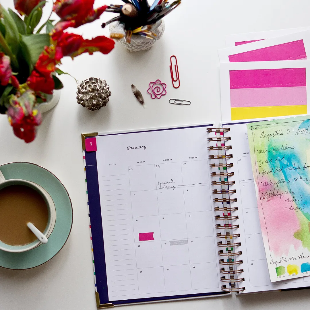 Mein Beckenbodenworkout – Starker Beckenboden Kraft 6 Schreibtisch-Arrangement mit Kalender, Kaffee, Blumen, Stiften und Notizen