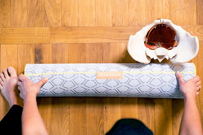 Mein Beckenbodenworkout – Starker Beckenboden Kraft 3 Frauenhände auf Yoga-Matte mit Schale und Blumen, Trainingsszene