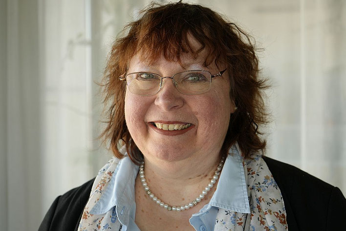 Porträt von Monika Müller-Herrmann, Therapeutin mit Brille und Perlenkette