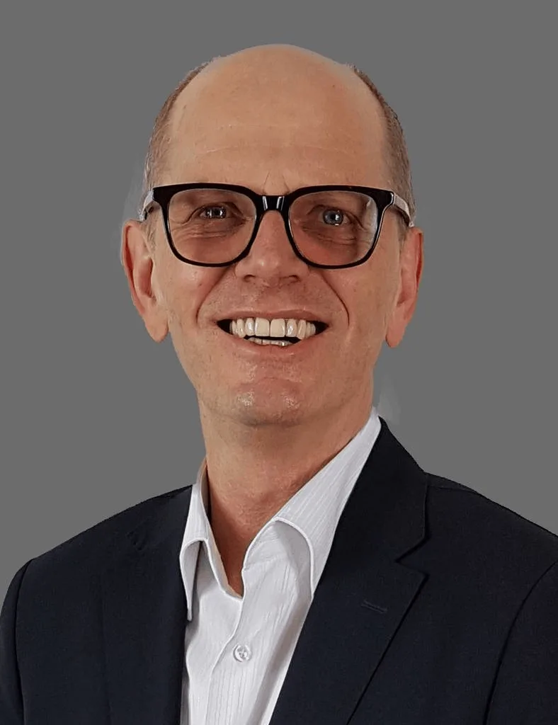 Porträt von Jürgen Schrödter, Mann mit Brille, dunklem Blazer und weißem Hemd