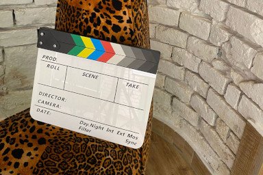 Film-Klappbrett auf leopardengemustertem Sessel