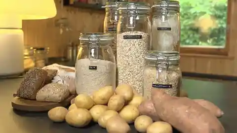 Lagerungsboxen mit Getreide, Kartoffeln und Gemüse auf Küchentheke
