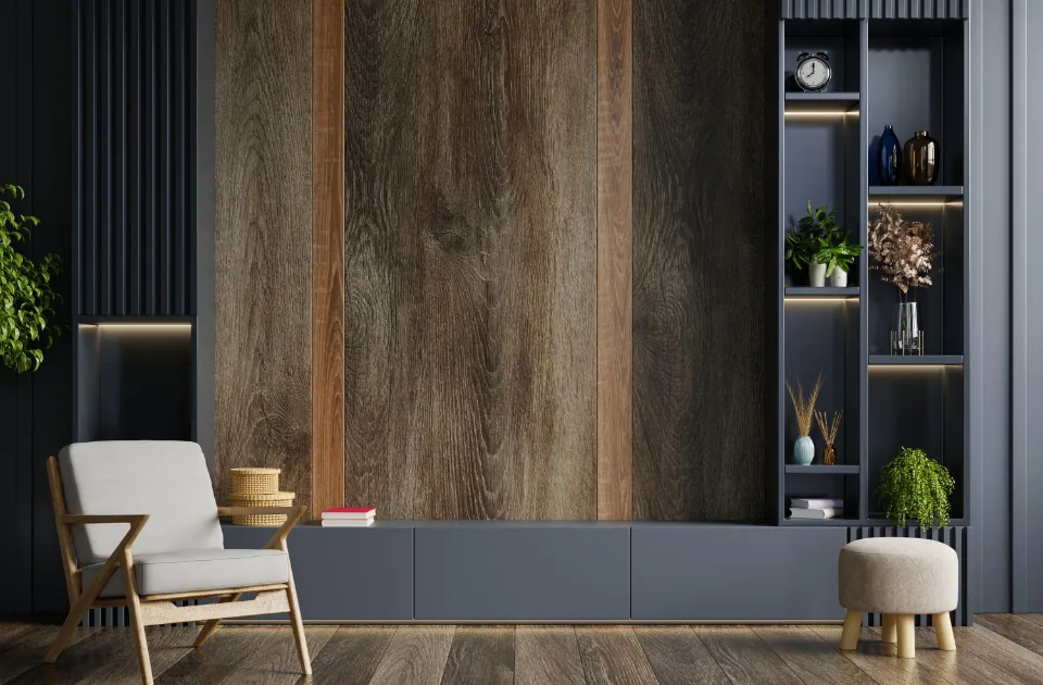 Wohnzimmer mit dunkler Holzwand, grauem Sideboard, Sessel und beleuchteten Wandregalen