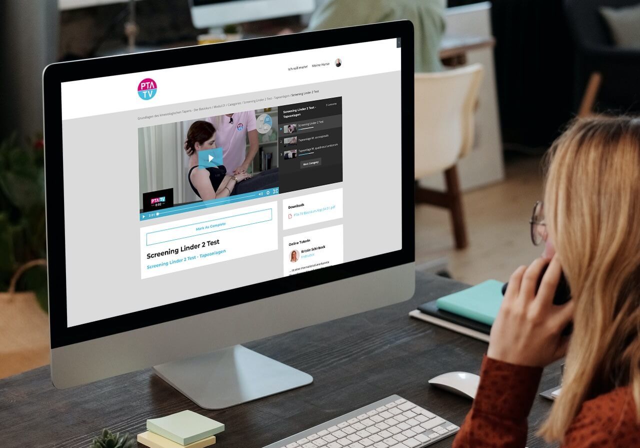 iMac Computer zeigt PTA TV Kursseite "Screening Linder 2 Test" mit Video-Player im modernen Büro-Setting