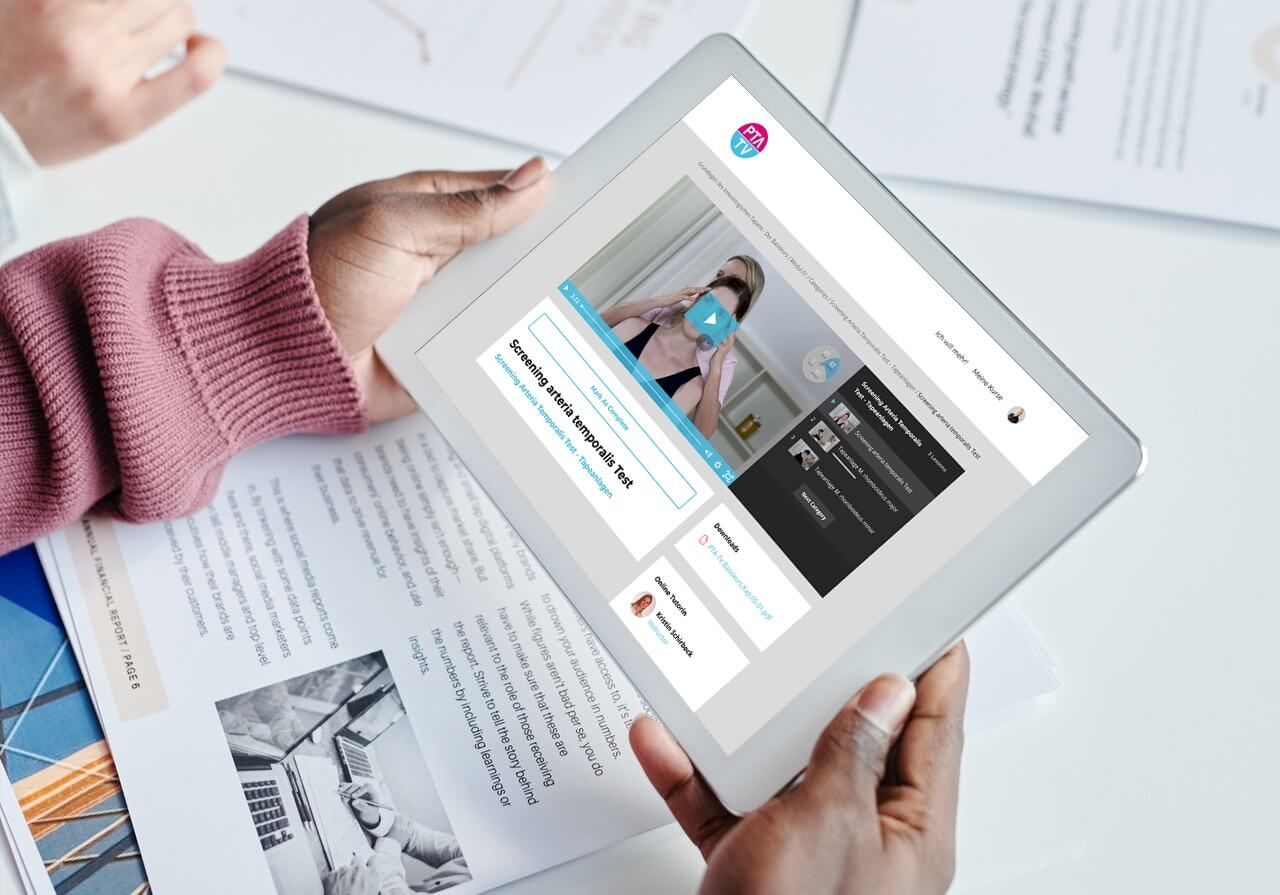 iPad in Frauenhand zeigt PTA TV Kursseite mit Video und Inhaltsübersicht auf Dokumenten-Untergrund