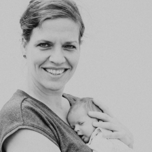 Porträt Theresa Wies, Frau mit dunklem Haar mit Baby in Schwarz-Weiß