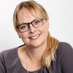 Dr. rer. med. Nicole Winkle, Frau mit Brille und rötlichblondem Haar im dunklen Oberteil