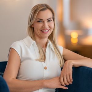 Maria Diab, Frau mit grauem Haar vor Wasser und Sonnenuntergang