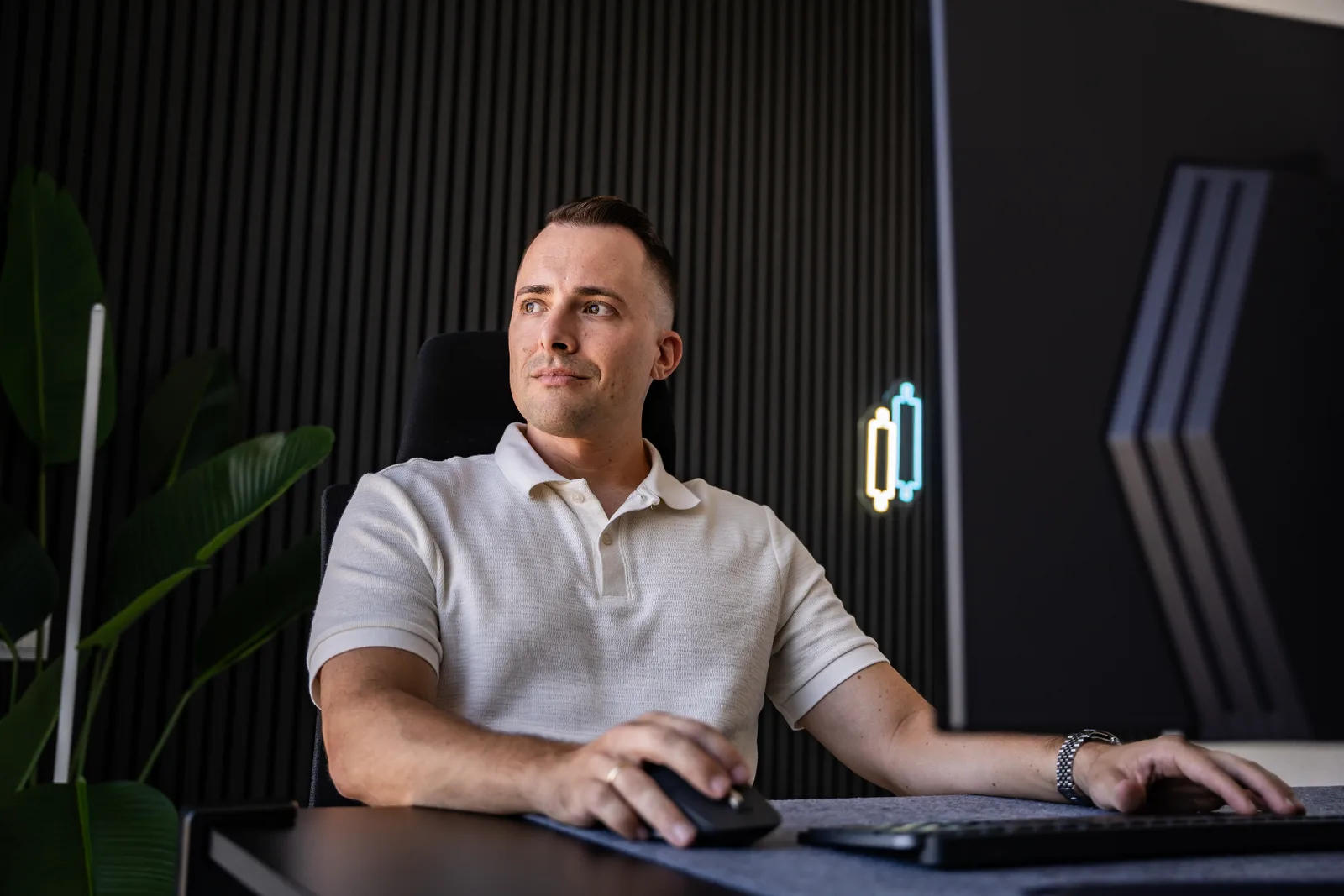 Momentum Flow Strategie – Trading-Videokurs von Marco Reis 16 Marco Reis Portrait in weißem Polo-Shirt am Schreibtisch, professionelles Büro-Setting mit Neon-Elementen