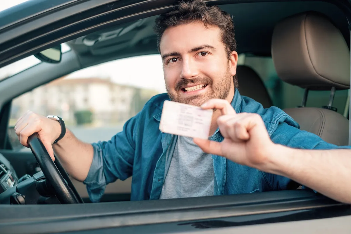 MPU-Vorbereitung online – mit Plan zurück zum Führerschein 7 Mann am Steuer zeigt seinen Führerschein in die Kamera