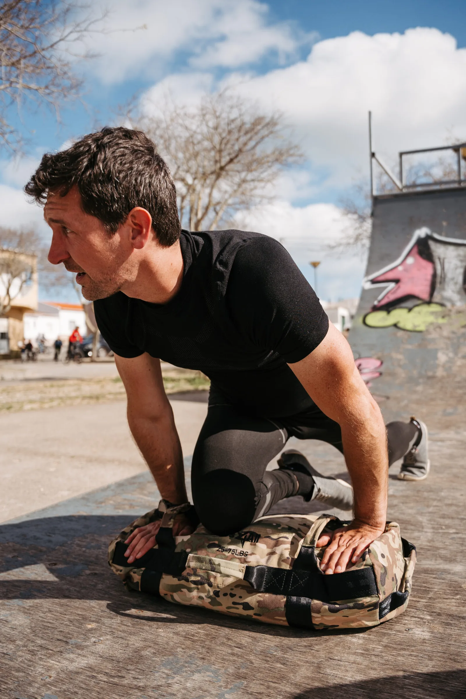 Mann in Push-Up-Position auf Sandsack mit konzentriertem Gesichtsausdruck