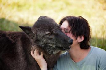 Kerstin Krahwinkel mit schwarzem Wolf beim intimen Körperkontakt