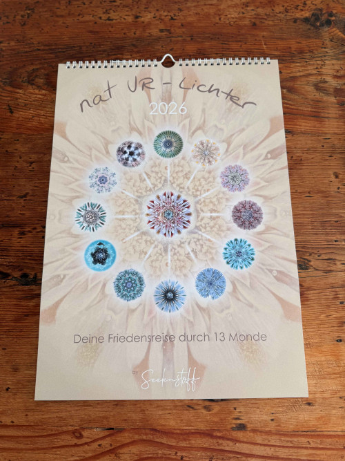 natUR-Lichter Kalender 2026 Produktabbildung aufgeschlagen auf Holztisch mit Spiralbindung