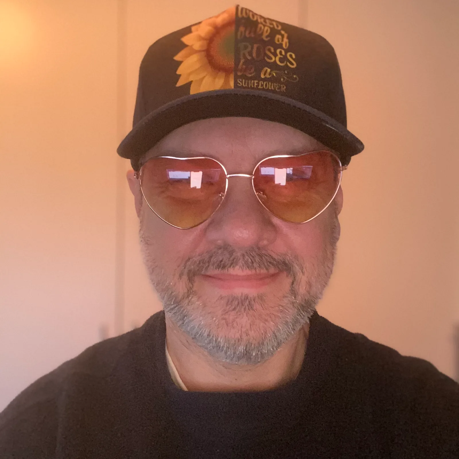 Mann mit Sonnenbrille und Kappe in warmem Licht, lockeres Portrait