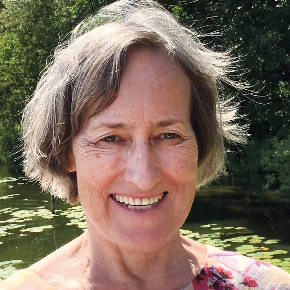 Porträt einer älteren Frau mit grauen Haaren, vor Wasser mit Seerosen