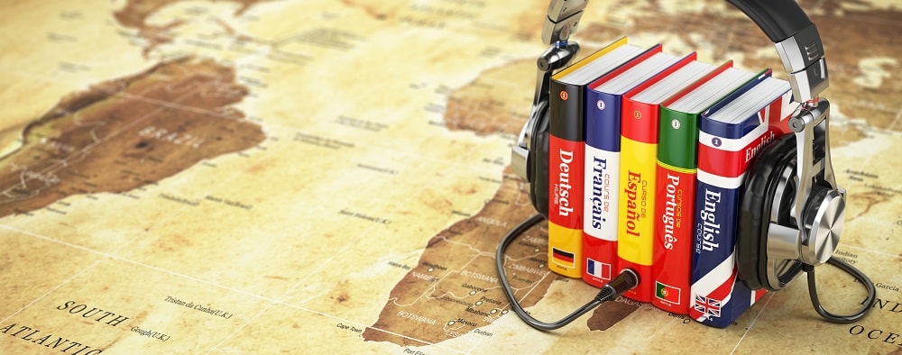 Wörterbücher in verschiedenen Sprachen auf Weltkarte mit Kopfhörer