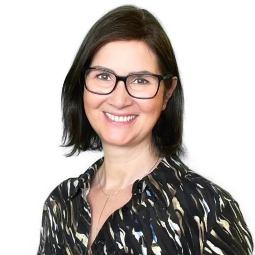Porträt Andrea Hammer, Frau mit Brille und schwarzem Haar vor weißem Hintergrund