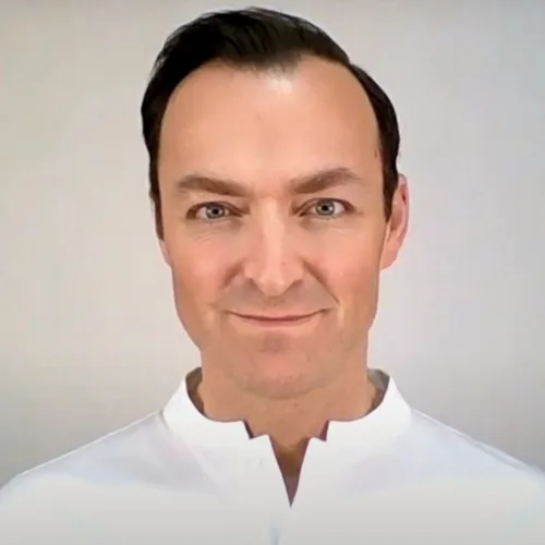 Portraitfoto von Wolfgang Ehß, Mann mit dunklem Haar, weißem Hemd, grüner Natur-Hintergrund