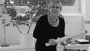 Annette Kunow am Schreibtisch mit Dokumenten, schwarz-weiß Portrait bei der Arbeit
