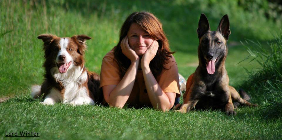Johanna Esser mit zwei Hunden auf Wiese, braun-weiß und schwarz