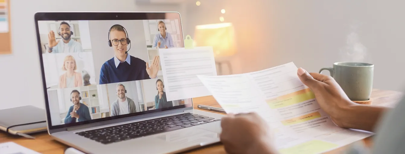 Online-Sprechstunde für Ihre IHK-Projektarbeit 3 Online-Videokonferenz mit mehreren Teilnehmern auf Laptop-Bildschirm, Dokumentenausdruck und Kaffeetasse auf Schreibtisch