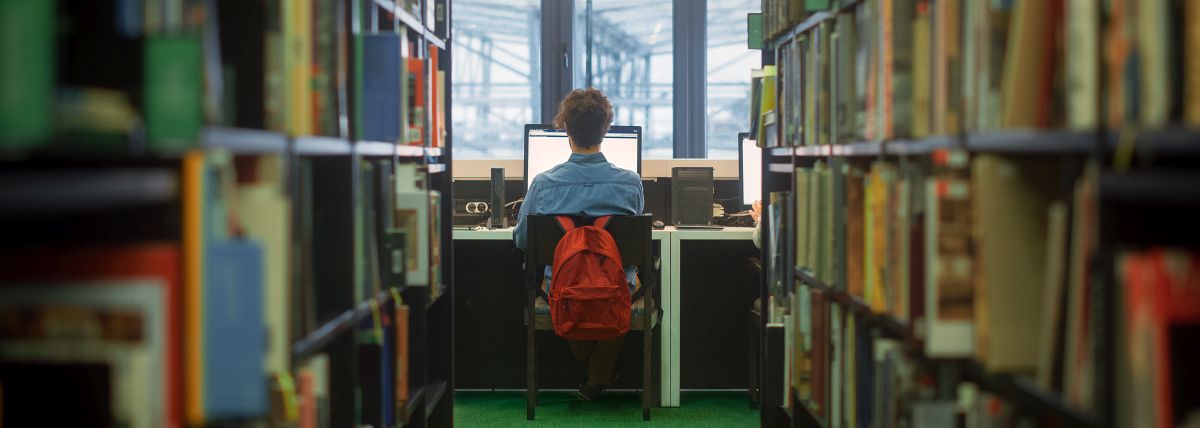 Online-Sprechstunde für Ihre IHK-Projektarbeit 7 Student mit rotem Rucksack sitzt in Bibliothek am Computer, Text über erfolgreiche IHK-Projektarbeiten