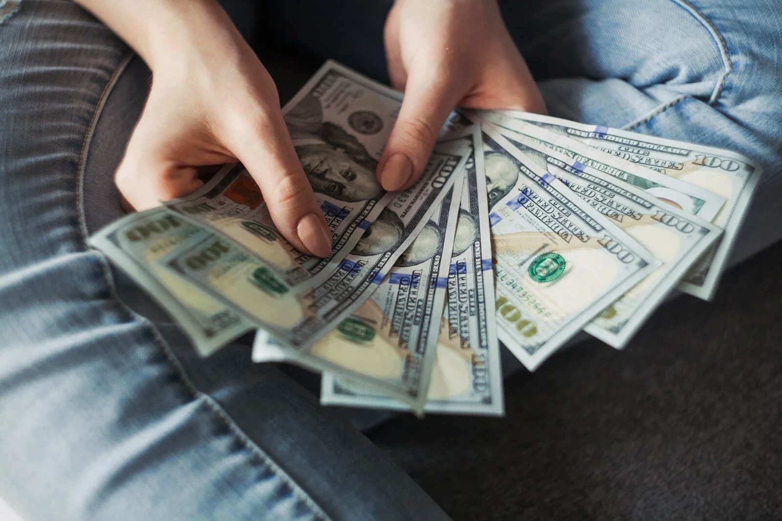 OTP Premium Mitgliedschaft – Trading-Kurs mit Journalvorlage 4 Hände halten gefächerte US-Dollar-Geldscheine