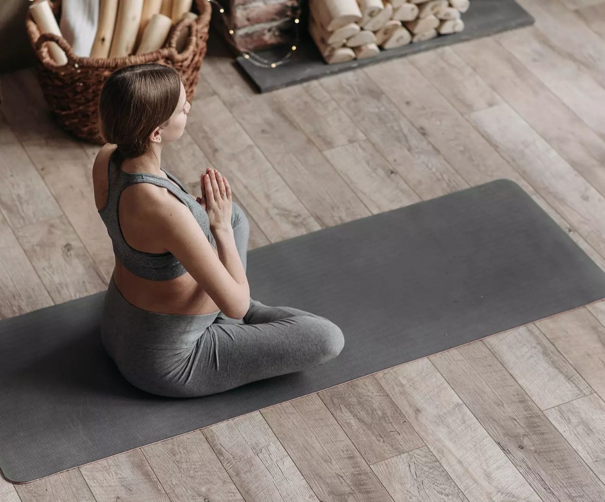 OTRANG – Trainer-Onlinekurs Rückbildung von Dr. Iris Floimayr-Dichtl 6 Frau in Yogaposition auf Trainingsmatte in modernem Wohnzimmer