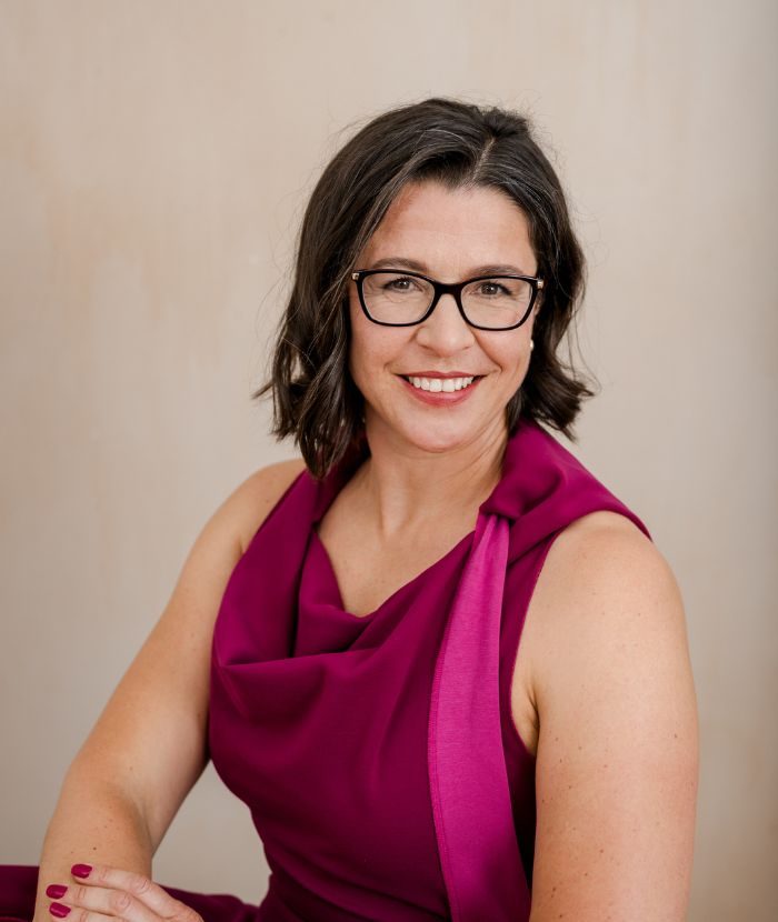 OTRANG – Trainer-Onlinekurs Rückbildung von Dr. Iris Floimayr-Dichtl 20 Dr. Iris Floimayr-Dichtl, Gründerin von mamaFIT, Portrait mit Brille und Magenta-Oberteil