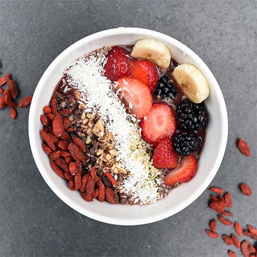 Gesundes Frühstück Açai Bowl mit Beeren, Kokos und Banane