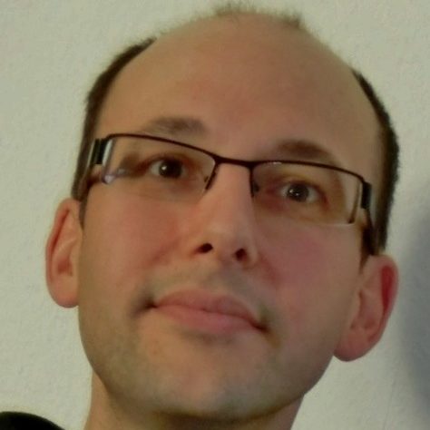 Mann mit Brille und grauem T-Shirt – Kundenstimme Oliver