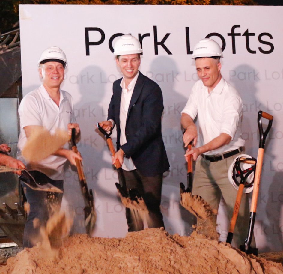 Drei Männer mit weißen Helmen bei Spatenstich auf Park Lofts Baustelle