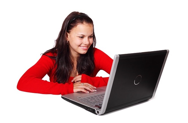 Frau mit langen dunklen Haaren in rotem Blazer arbeitet am Laptop
