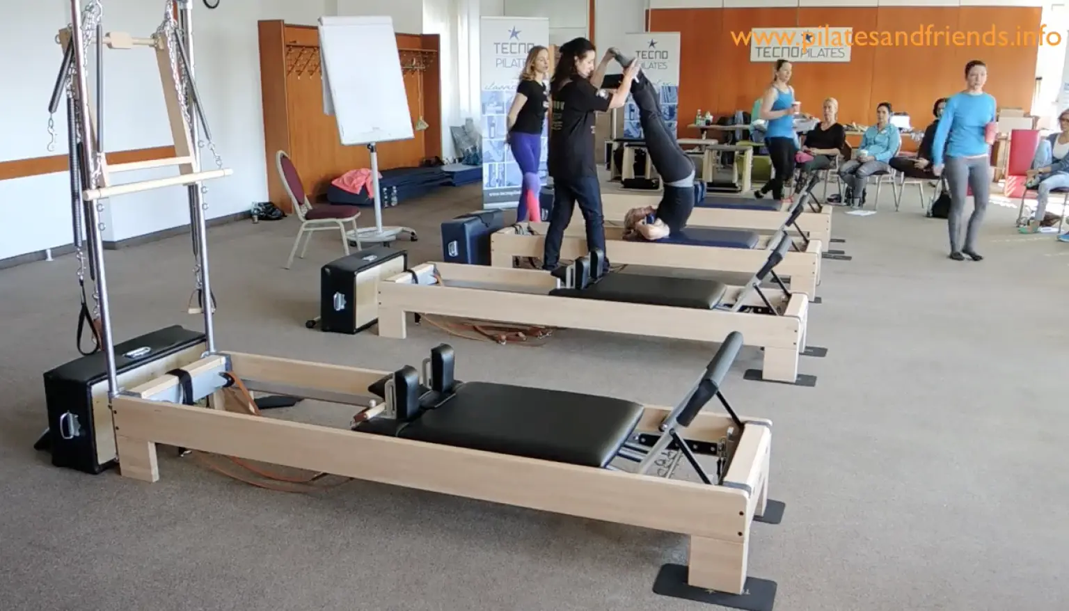 Pilates-Reformer-Geräte mit Teilnehmern beim Gruppentraining im Studio