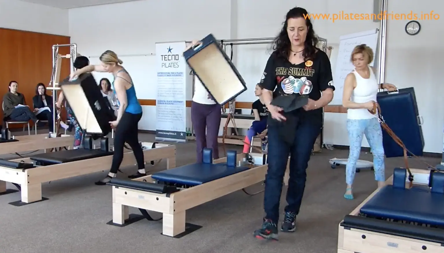 Reformer-Pilates-Instruktorin demonstriert Übung mit springenden Bewegungen