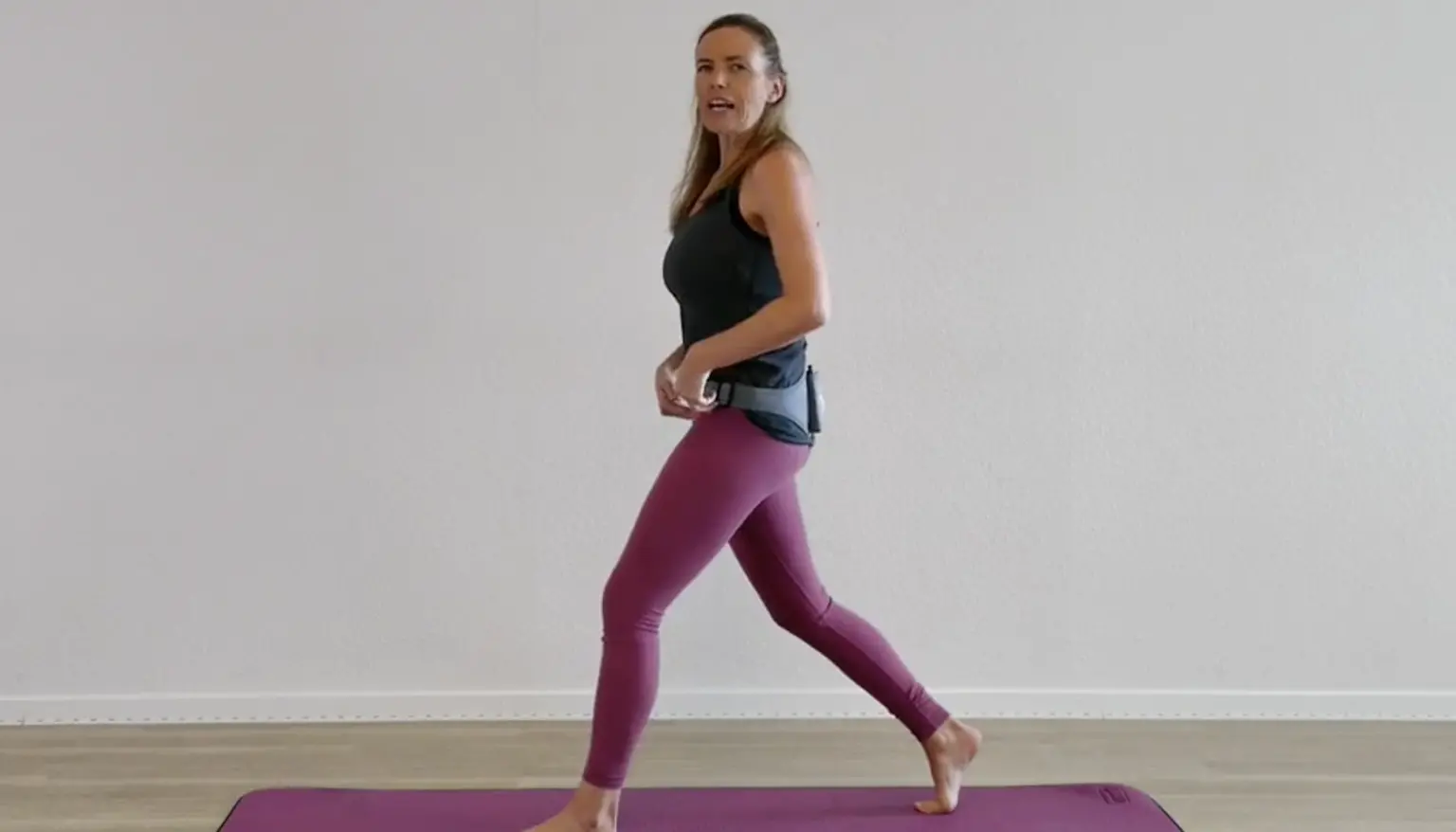Frau in schwarzem Top und burgunderfarbenen Leggings beim Joggen