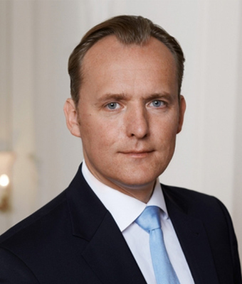 Porträt Dr. Thorsten Polleit, Mann mit dunklem Haar, blauem Hemd und Krawatte