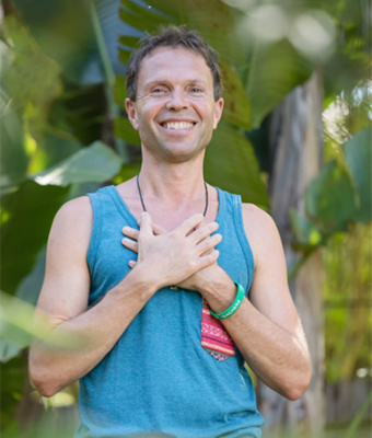 Porträt Matthias Langwasser, Mann in blauem Top, Hand auf Brust, Naturhintergrund