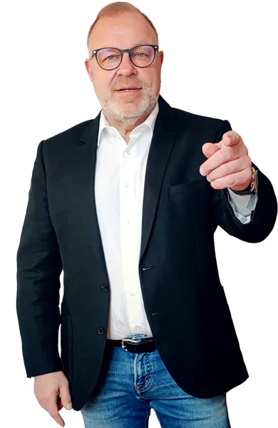 Christian Schütte Portrait, Geschäftsführer in Business-Anzug mit Geste, zeigt auf Kamera